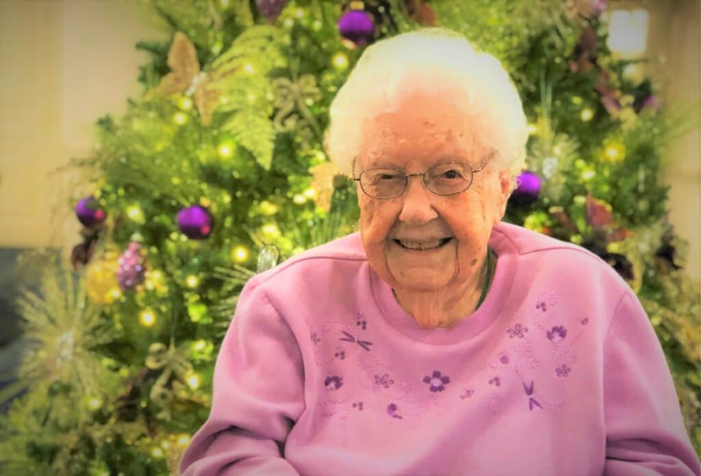 Elderly woman smiling indoors seated on chair