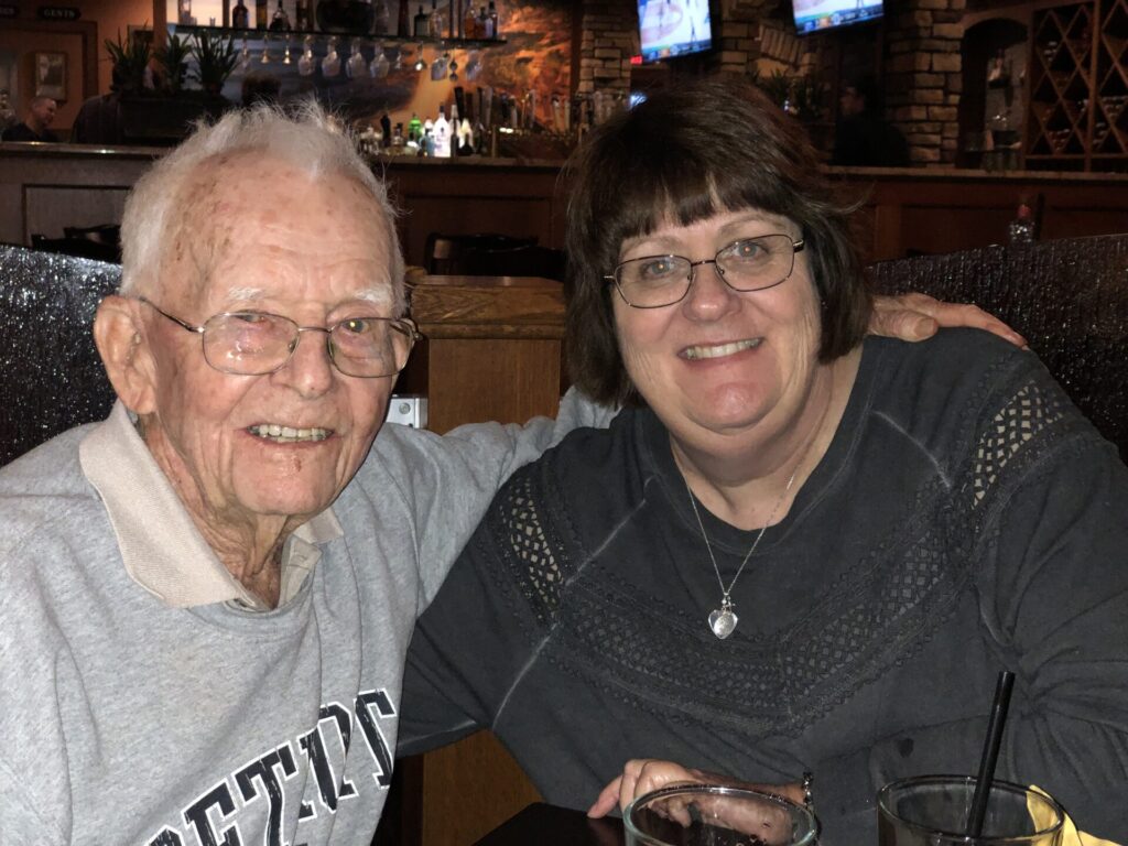 Two elderly men smiling indoors during event
