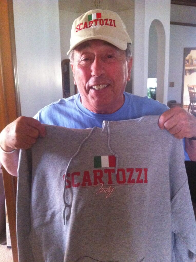Elderly man smiling while standing outside in casual wear
