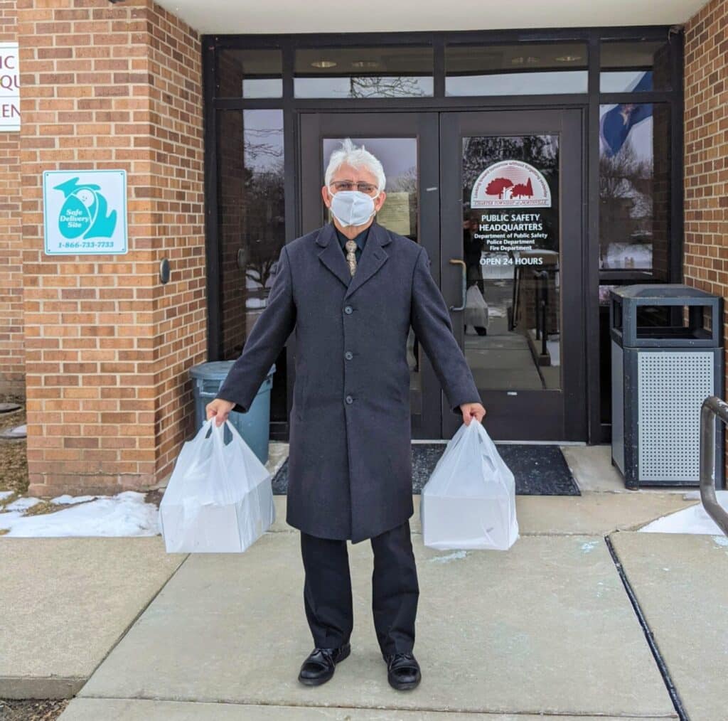 Senior man in black coat standing outdoors in front of building