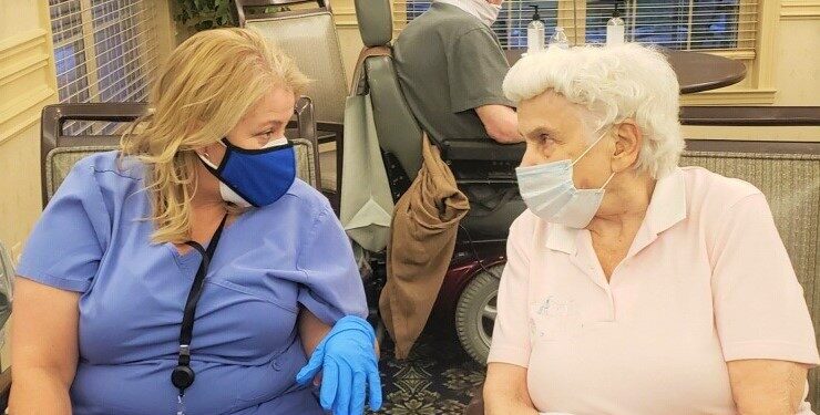 Group of seniors sitting in lounge chatting together