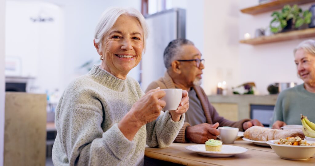 group of seniors in the living room of a community home for a social gathering
